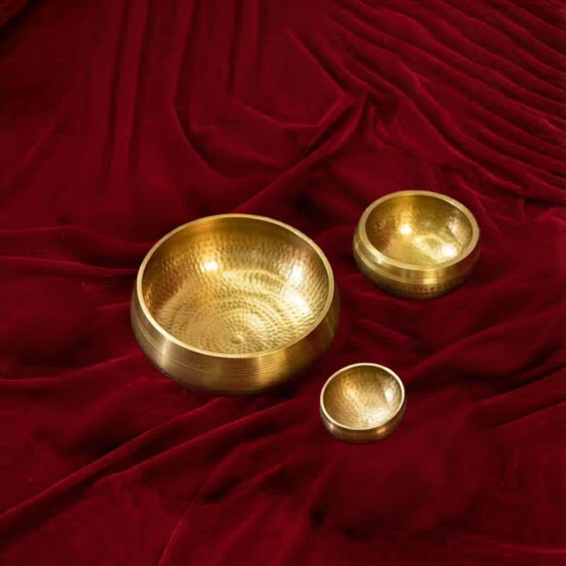 Extended set of 5 chakra singing bowls with mallets on dark wood