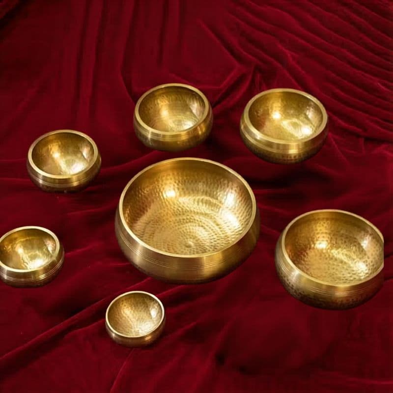 Complete set of 7 chakra singing bowls with mallets on dark wood