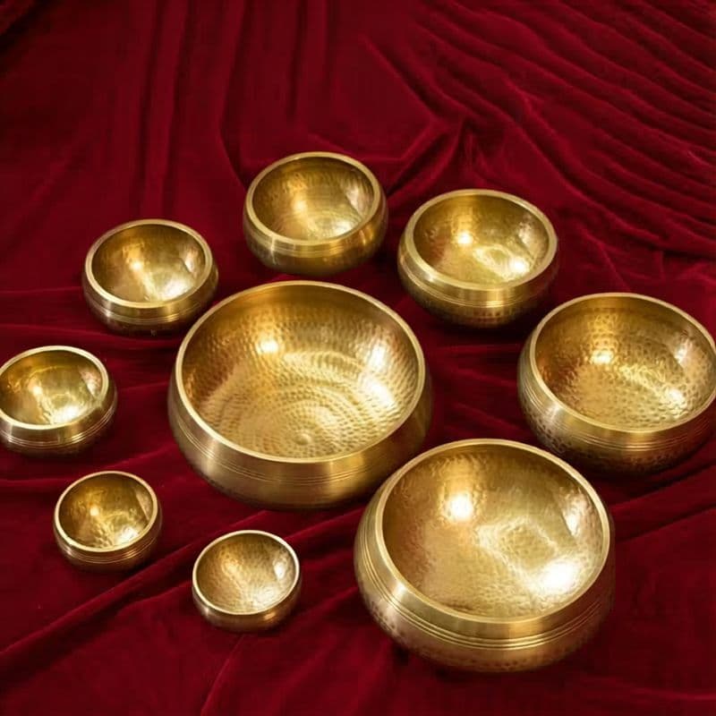 Master set of 9 chakra singing bowls with mallets on dark wood